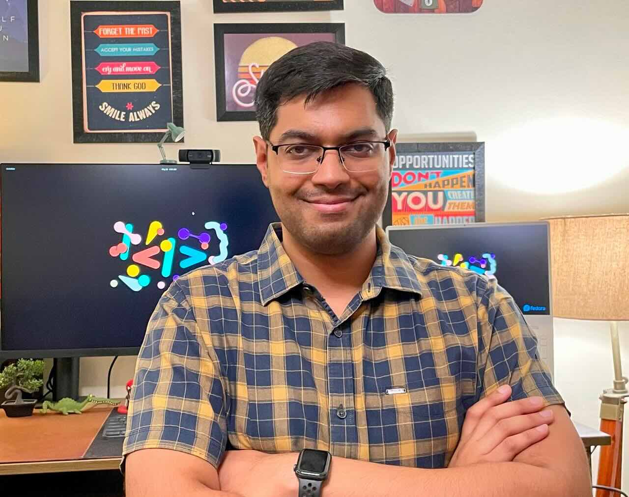 Anurag sitting in front of his computer monitor with a big smile on his face.